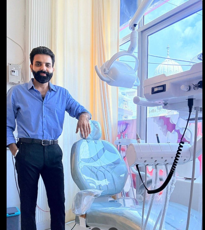 Dr. Anish Sharma beside a modern dental chair at Dental 4 All